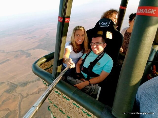 Cory Lee and his mum Sandy in a hot air balloon travelling over a desert scene