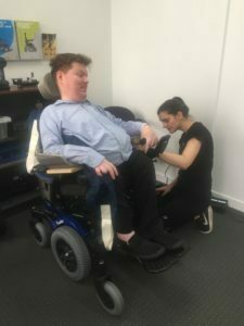 Wheelchair experts fitting wheelchairs.