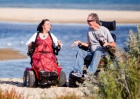 Two wheelchair users on the beach