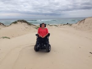 Nicky in the sand on her Masgic Mobility Extreme X8treme X8.