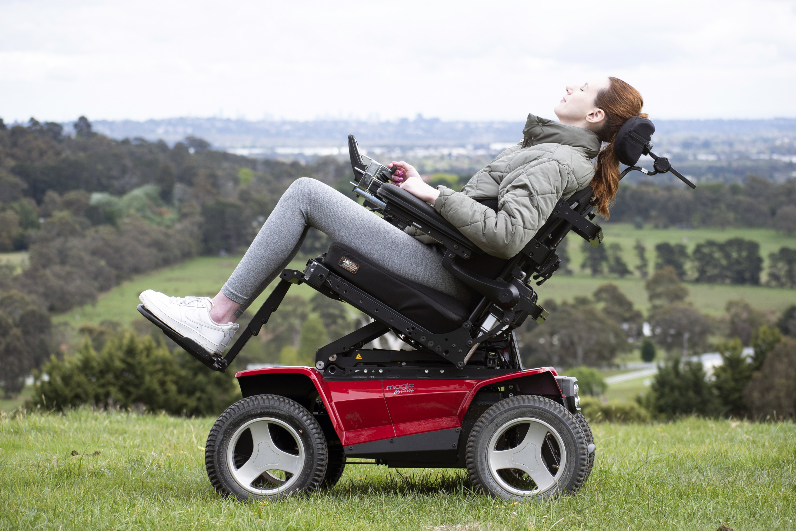 Wheelchair user tilting back in her seat to rest and adjust her position.