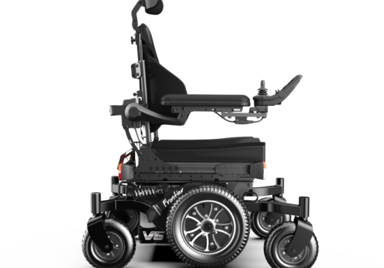 Black powered wheelchair with joystick control, headrest, and large rear wheels visible from the side.